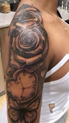 a woman with a rose and clock tattoo on her arm