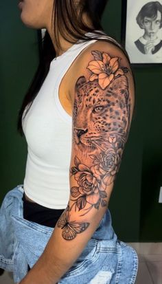 a woman with a leopard and flowers tattoo on her arm