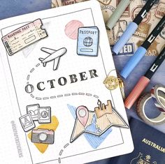 an open notebook sitting on top of a table next to travel related items and passport