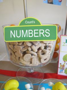 a table with two clear bowls filled with cookies and marshmallows in the shape of ducks