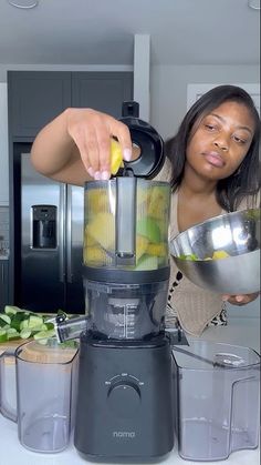 a woman is preparing food in a blender