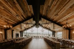 a large dining hall with wooden walls and chandeliers hanging from it's ceiling