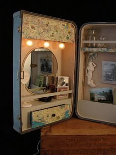 an open suitcase that is sitting on top of a wooden box with its reflection in the mirror