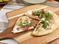 a wooden cutting board topped with two slices of pizza