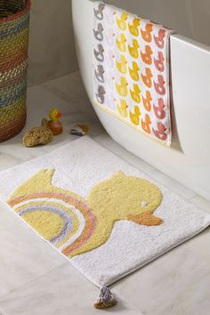 a bathroom rug with a rubber ducky on the floor next to a bathtub