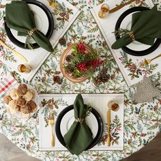 the table is set with place settings and napkins for christmas dinner guests to enjoy