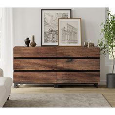 a large wooden dresser sitting in a living room next to a white couch and potted plant