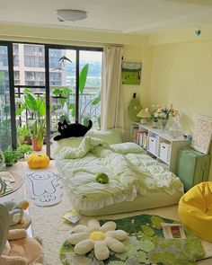 a room filled with lots of furniture and plants on the floor in front of large windows