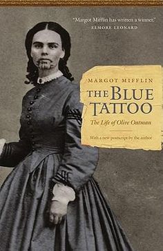 a book cover with an image of a woman in a blue dress and the title, the blue tattoo