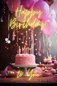 a birthday cake with lit candles and pink frosting surrounded by confetti and balloons