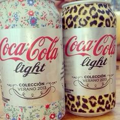 two cans of coca - cola light on a table