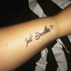 a person with a tattoo on their arm that says just breathe