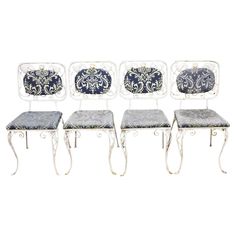 four chairs with blue and white designs on the back, one is upholstered