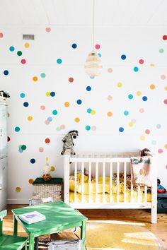 a child's room with colorful polka dot wallpaper