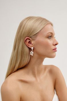 a woman with long blonde hair and earrings on her head, looking off to the side