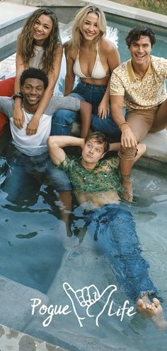 four people are posing in the pool together