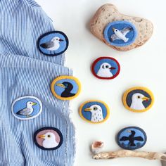 some birds and seagulls are embroidered onto the buttons on this blue striped shirt