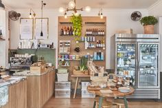 the inside of a store with lots of items on shelves and wooden tables in front of it