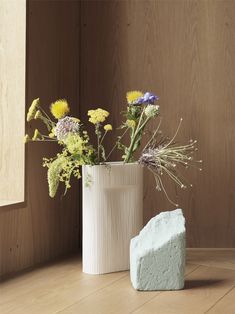 two vases filled with flowers sitting on top of a wooden floor