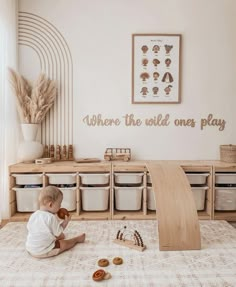 a baby sitting on the floor playing with toys in a playroom that says, where the wild ones play