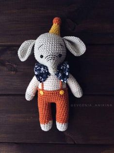 a crocheted stuffed animal wearing an orange and white outfit