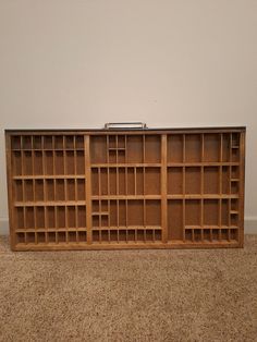 a wooden bookcase sitting on top of a carpeted floor next to a wall