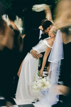 a bride and groom kissing in front of their guests