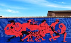 a mural on the side of a building depicts men playing with a tiger and other animals