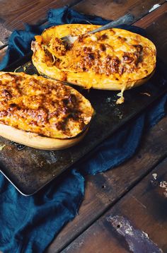 two baked breads sitting on top of a metal tray next to a blue cloth