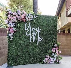 a sign that says you are surrounded by flowers and greenery in front of a building