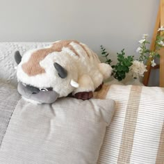 a stuffed animal laying on top of a pillow