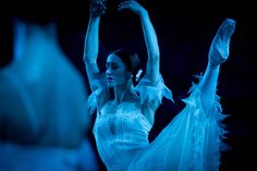 a woman in white dress dancing on stage