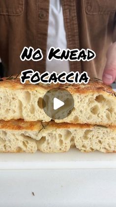 a person holding a piece of bread with the words no knead focaccia on it