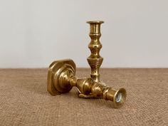 an antique brass candle holder on the floor