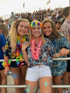 two girls are posing for the camera in front of a crowd