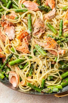 pasta with asparagus, salmon and parmesan cheese in a skillet