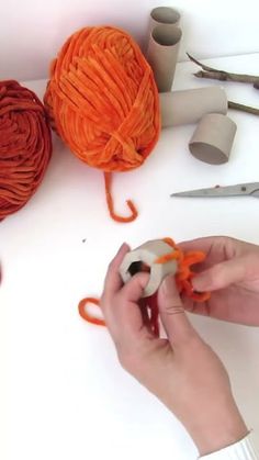 a person is knitting yarn on a table