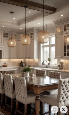 a dining room table and chairs with lights hanging from the ceiling above it in a kitchen