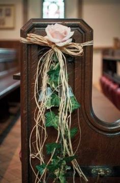 a rose is tied to the back of a church pew