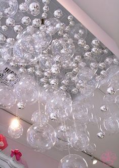 a chandelier hanging from the ceiling with lots of clear glass balls on it