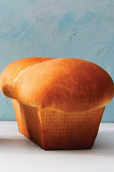 a loaf of bread sitting on top of a white counter next to a blue wall