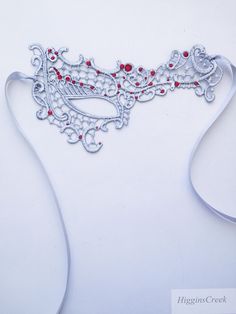 We offer original handcrafted embellishment designs for your mask. We can customize any mask to create a wearable work of art unique to you!Silver Masquerade Mask women Lace Red rhinestones Mardi Gras Mask These subtle yet seductive masks are each intricately embroidered to be a gorgeous addition to any costume or party dress that will transform you into a mystifying beauty of the night!  This pattern compliments all face shapes and is very comfortable to wear. Its also ideal to wear with eye gl Silver Rhinestone Eye Masquerade Mask, Silver Rhinestone Eye Mask For Masquerade, Red Eye Mask As Gift, Red Eye Mask For Gift, Red Eye Mask As A Gift, Silver Masquerade Mask With Rhinestones For Costume Party, Silver Rhinestone Masquerade Mask For Costume Party, Silver Rhinestone Masquerade Mask For Carnival, Elegant Silver Masks As Gift