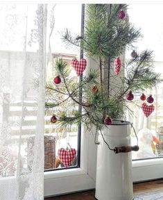 a white vase filled with christmas decorations next to a window