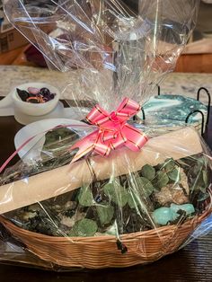 a basket filled with lots of rocks and wrapped in cellophane on top of a table