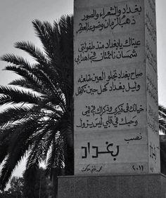 a monument with arabic writing on it and palm trees in the backgrouds