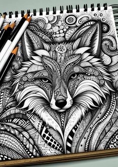 a drawing of a fox with intricate patterns on it's face and eyes, surrounded by pencils