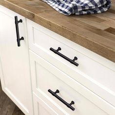 a kitchen counter top with black handles on it