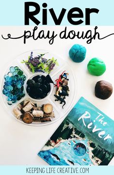 the river play dough is on a plate next to a book and other items that include rocks