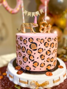 a pink cake with leopard print and gold decorations