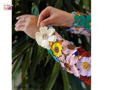 a woman's hand is holding an object with flowers on it